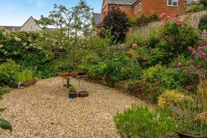 A garden with a gravel path, potted plants, and a wooden fence. - 4 Bed in Swanage (oc-p44708) (Swanage)