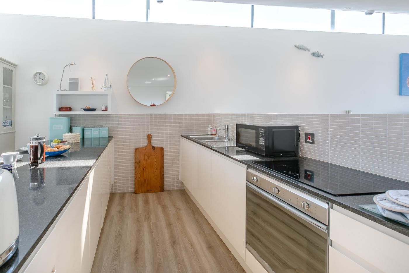 Une cuisine moderne équipée d’un four à micro-ondes, d’une cuisinière et d’une planche à découper en bois.