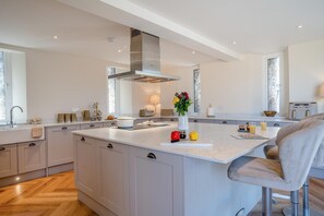 Una cocina moderna con una isla grande, electrodomésticos de acero inoxidable y una paleta de colores neutros.