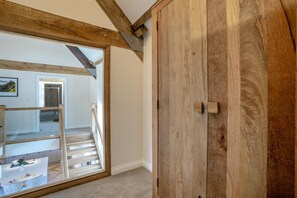 Una habitación con un armario de madera, una puerta de cristal que da a una escalera y vistas a un comedor.