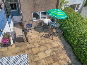 A patio with a grill, outdoor seating, and a large bush. - 2 Bed in Penmachno (oc-y44743) (Penmachno)