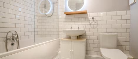 A bathroom with a bathtub, a sink, a toilet, and a shower.
