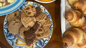 A table with various baked goods including pies, cookies, and croissants. - Beautiful 4-bedroom resort with AC in tranquil Pompei (POMPEI)