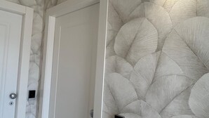 A room with a textured wall, a white door, and a light fixture. - Beautiful 4-bedroom resort with AC in tranquil Pompei (POMPEI)