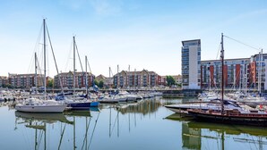 A marina with various boats docked, surrounded by multi-story buildings. - 2 Bed in Maritime Quarter (oc-m44948) (Swansea)