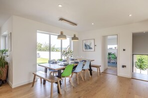 A dining area with a wooden table, chairs, and pendant lights. - 5 Bed in Upton (oc-m44891) (Darley)