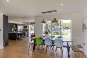 A modern kitchen with a dining area, large windows, and a view of the outdoors. - 5 Bed in Upton (oc-m44891) (Darley)