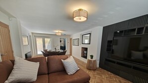 A modern living room with a brown sofa, a TV, and a fireplace. - 4 Bed in Hampeth (oc-w45221) (Shilbottle)