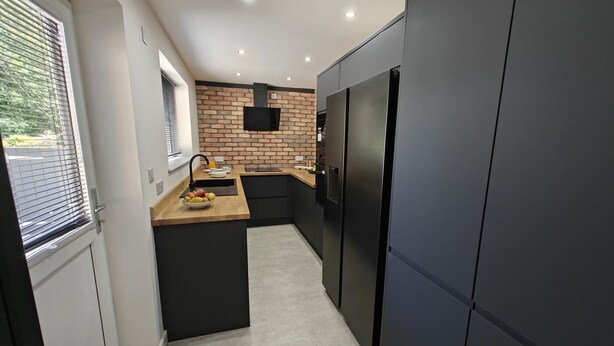 A modern kitchen with a brick backsplash, a built-in oven, and a large refrigerator. - 4 Bed in Hampeth (oc-w45221) (Shilbottle)