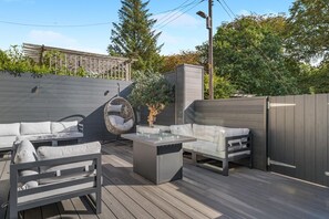An outdoor patio with a wooden deck, a hanging chair, a sofa, and a table. - 4 Bed in Hampeth (oc-w45221) (Shilbottle)