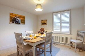 A dining area with a table set for four, chairs, a radiator, and a window with blinds. - 3 Bed in Forest Row (oc-h43282) (Forest Row)