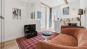 Ett vardagsrum med en soffa, en tv, ett soffbord och en matta.