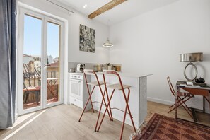 Eine moderne Küche mit Essbereich, einem großen Fenster und Außenblick.