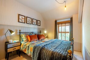 A bedroom with a bed, bedside tables, a lamp, framed artwork, and a window with curtains. - 2 Bed in Rhydyclafdy (oc-b44972) (Buan)