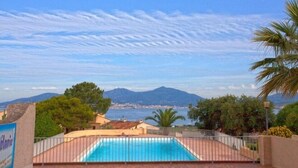 En swimmingpool med utsikt över havet och bergen.