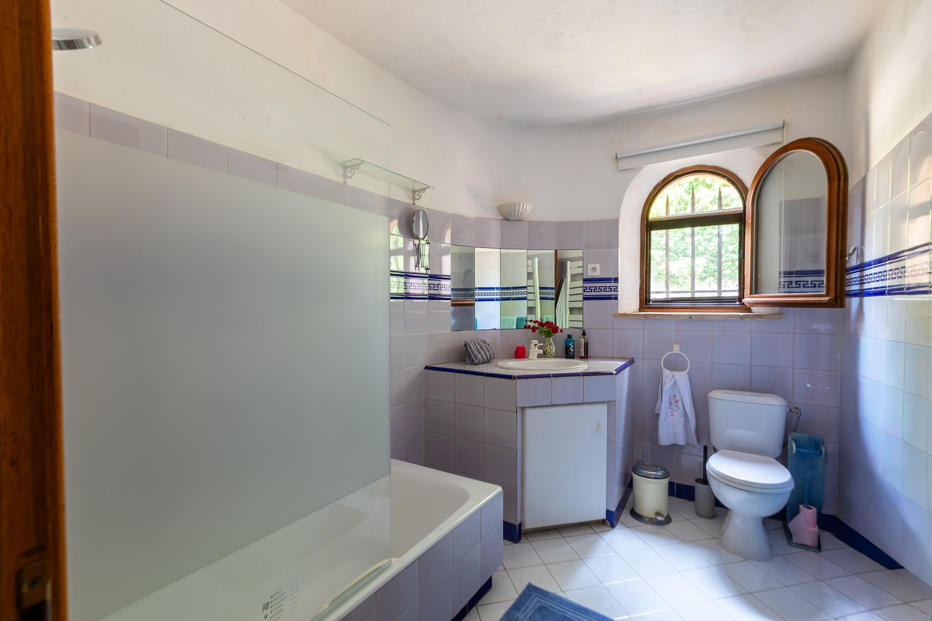 Une salle de bain avec une baignoire, des toilettes, un lavabo et un miroir.