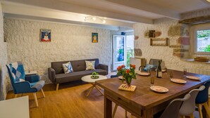 A living room with a sofa, a dining table set for four, and a coffee table.
