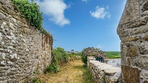 A stone pathway leading to a building with a view of the landscape.