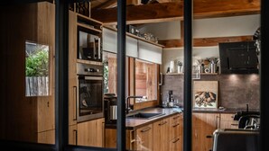 Una cucina compatta con mobili in legno, forno integrato, lavello e microonde.