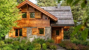 A wooden cabin with a stone foundation, wooden shutters, and a chimney. - Trancoulette - Five Bedroom Chalet, Sleeps 12 (La Salle-les-Alpes)