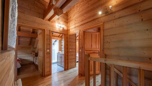 A wooden interior with a staircase, wooden doors, and a view to the outside. - Trancoulette - Five Bedroom Chalet, Sleeps 12 (La Salle-les-Alpes)