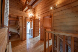 Ein Holzinnenraum mit Treppe, Holztüren und Blick ins Freie.