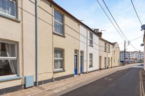 A row of terraced houses with a narrow street in between.