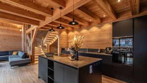 Una cucina moderna con travi in legno, un'isola centrale e un forno a incasso.
