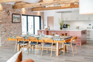 A dining area with a brick wall, wooden ceiling beams, and a table set for six. - 3 Bed in Aldfield (oc-f42083) (Aldfield)