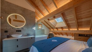 A bedroom with a skylight, a large round mirror, a bed, a nightstand, and a wooden ceiling. - Chalet Le Refuge - Five Bedroom House, Sleeps 14 (La Salle-les-Alpes)