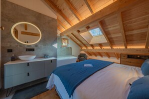 A bedroom with a skylight, a large round mirror, a bed, a nightstand, and a wooden ceiling. - Chalet Le Refuge - Five Bedroom House, Sleeps 14 (La Salle-les-Alpes)