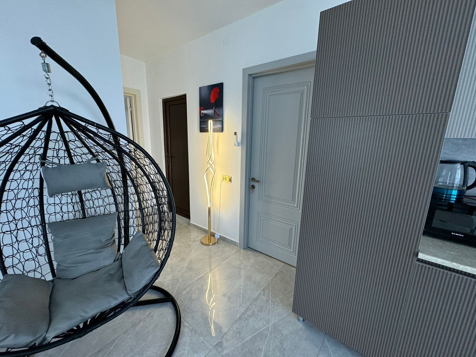 Ein modernes Interieur mit Hängekorbschaukel, einer Tür und einer Küchenzeile.