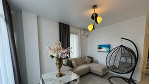Un salon moderne avec une table à manger, un canapé et un fauteuil suspendu.