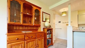 Un mueble de madera con varios cajones y estantes, un pequeño globo en la parte superior, y una biblioteca llena de libros.