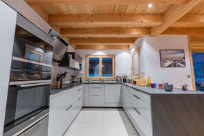 A modern kitchen with white cabinetry, a Siemens oven, and a wooden ceiling. - Aigle - Six Bedroom House, Sleeps 14 (Le Monêtier-les-Bains)