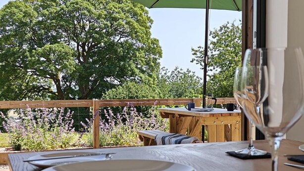 Ein Essbereich im Freien mit Tisch, Stühlen und einem Weinglas.