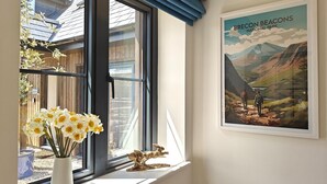 Ein Zimmer mit Fenster, einem Oregon Beacons Poster und einer Vase mit Blumen.