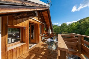 A wooden cabin with a balcony, a table with chairs, and a view of the mountains. - Acolin - One Bedroom Apartment, Sleeps 6 (Briancon)