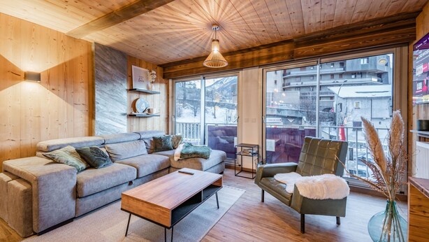 A cozy living room with a wooden ceiling, a sofa, a coffee table, and a chair. - Europa - Three Bedroom Apartment, Sleeps 8 (Briancon)