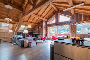 A log cabin interior with a loft bedroom, a dining area, and a kitchen. - Baikal - Five Bedroom Apartment, Sleeps 9 (La Salle-les-Alpes)
