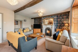 A living room with a fireplace, a television, and a sofa. - 4 Bed in Keswick (oc-b45231) (Keswick)