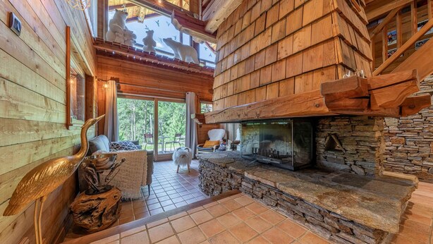 A wooden interior with a fireplace, stone accents, and a view of the outdoors. - Echyllo - Six Bedroom Chalet, Sleeps 14 (Saint-Chaffrey)
