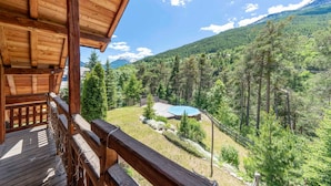 A wooden deck with a view of a mountain landscape and a pool area. - Echyllo - Six Bedroom Chalet, Sleeps 14 (Saint-Chaffrey)
