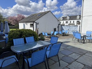 A patio area with tables and chairs, a small building, and a fence. - 3 Bed in Keswick (oc-b45232) (Keswick)