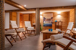 A spa room with wooden walls, a large painting, and multiple lounge chairs.