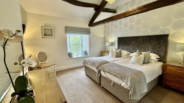 Un dormitorio con una cama grande, ventana, candelabro y espejo.