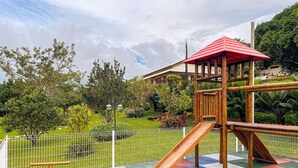 A playground with a slide, climbing structures, and a fenced area.