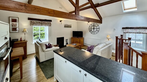 A spacious kitchen with a high ceiling, wooden beams, a built-in stove, and a large window. - 1 Bed in Keswick (oc-b45234) (Keswick)