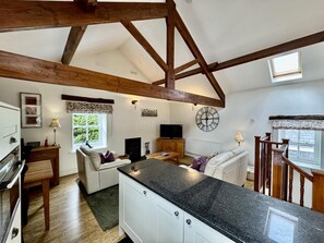 A spacious kitchen with a high ceiling, wooden beams, a built-in stove, and a large window. - 1 Bed in Keswick (oc-b45234) (Keswick)