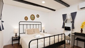 Una camera da letto con un letto, comodini, una scrivania, una sedia e uno specchio.